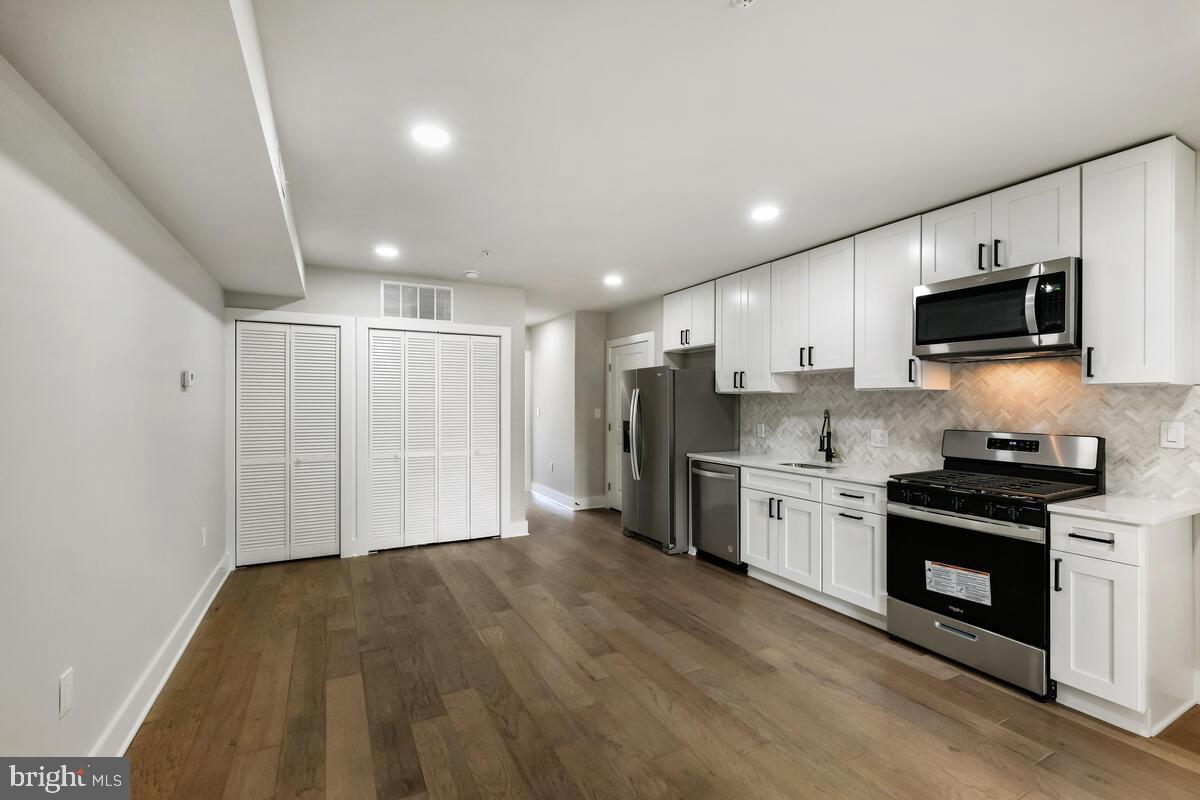 a kitchen with a sink a microwave a refrigerator and cabinets