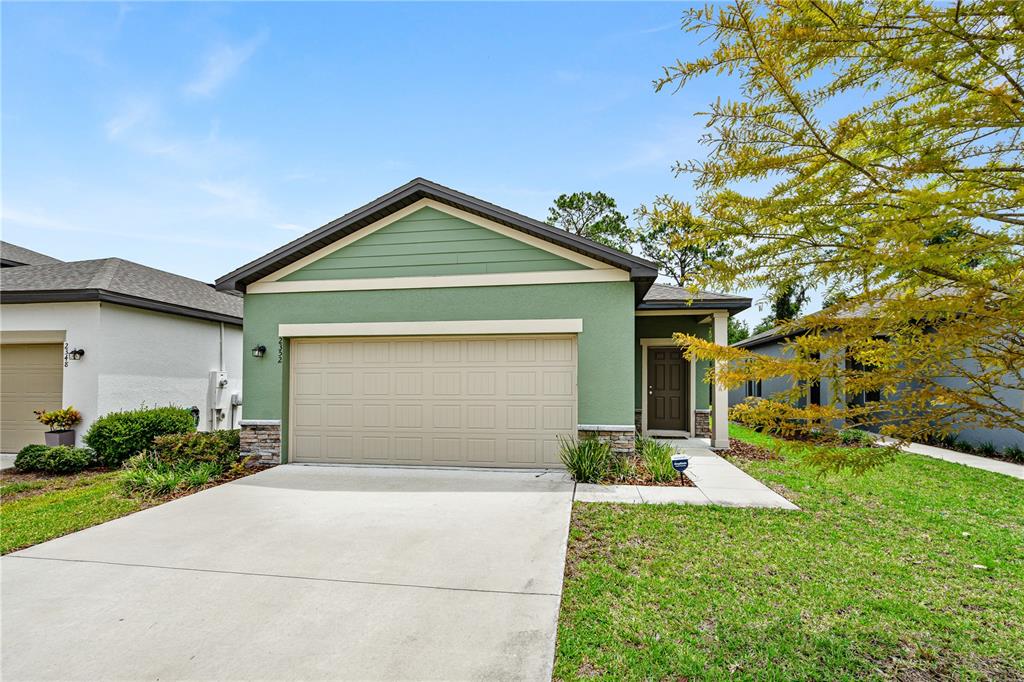 a front view of a house with a yard and garage