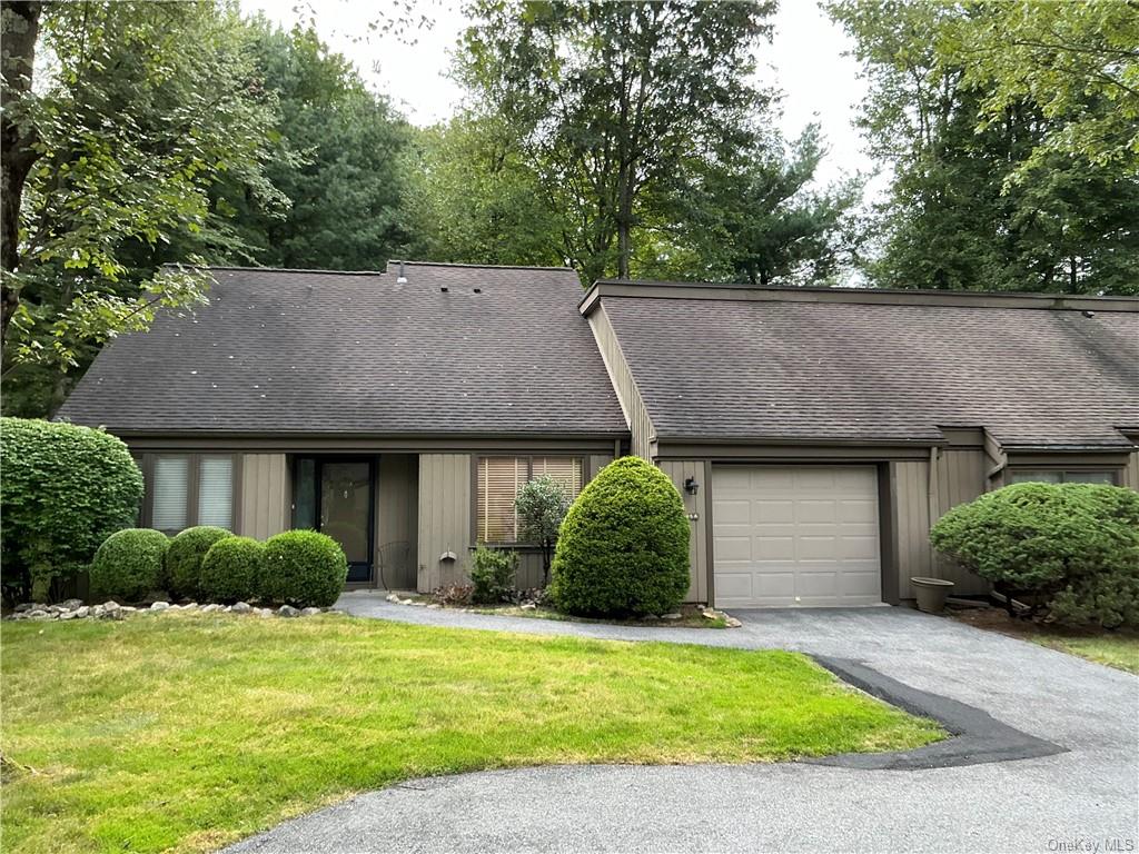 View of front of house featuring a garage and a front lawn