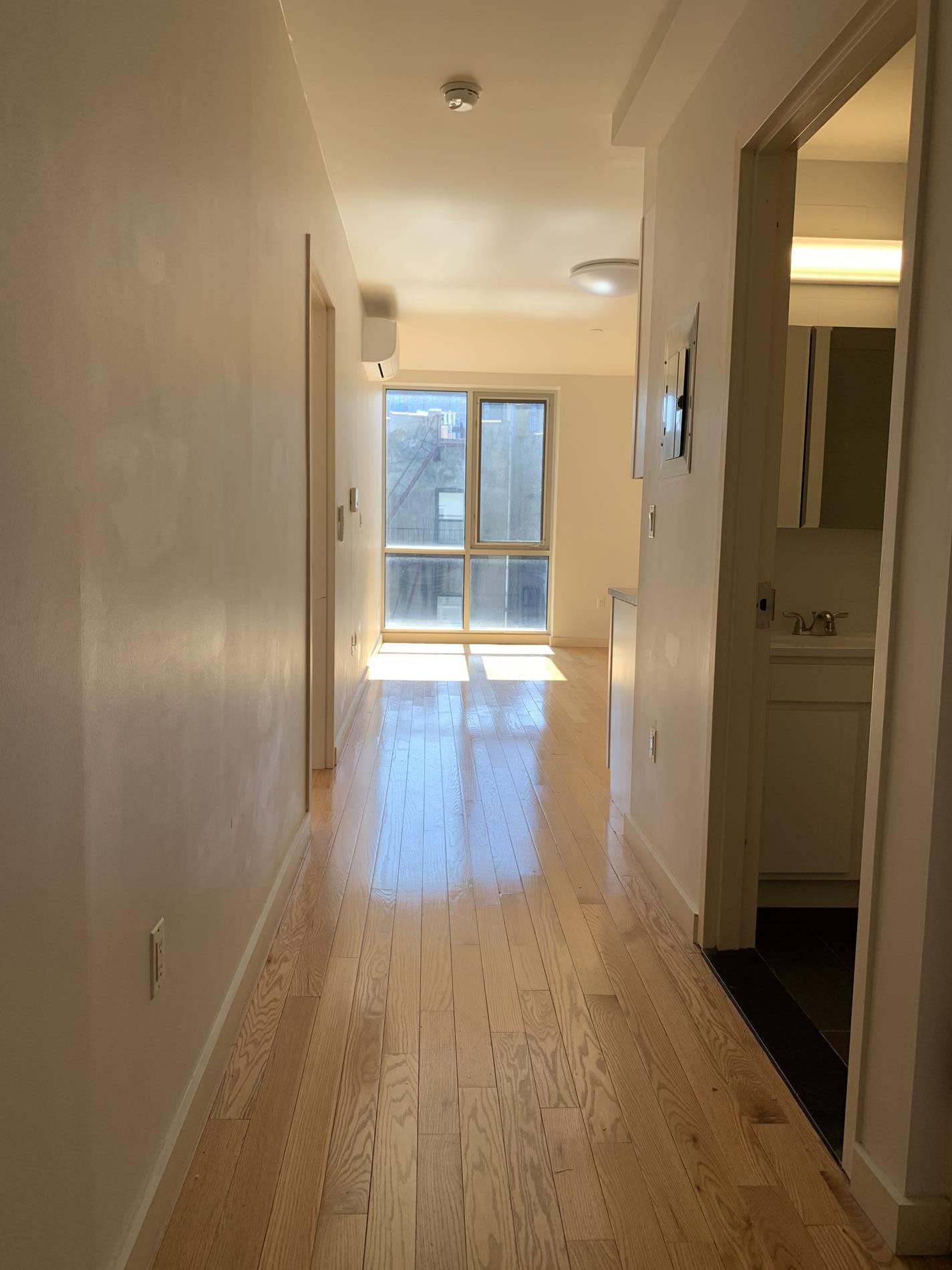 a view of a hallway with wooden floor