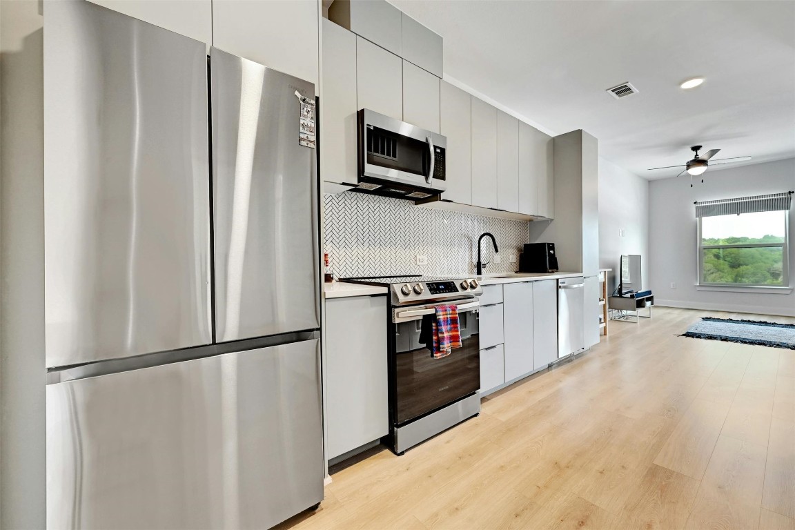 a kitchen with stainless steel appliances a refrigerator sink and microwave