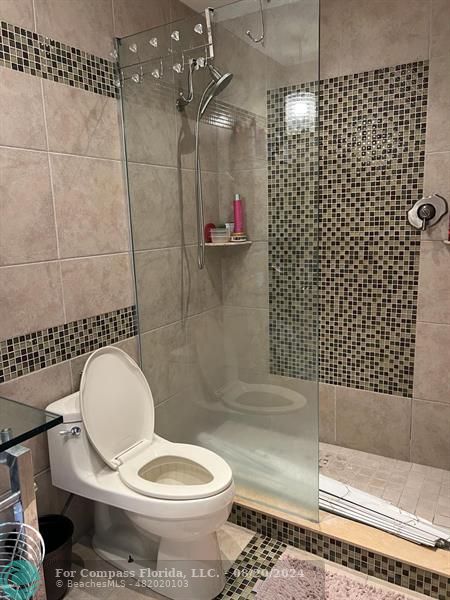 a bathroom with a toilet and a shower