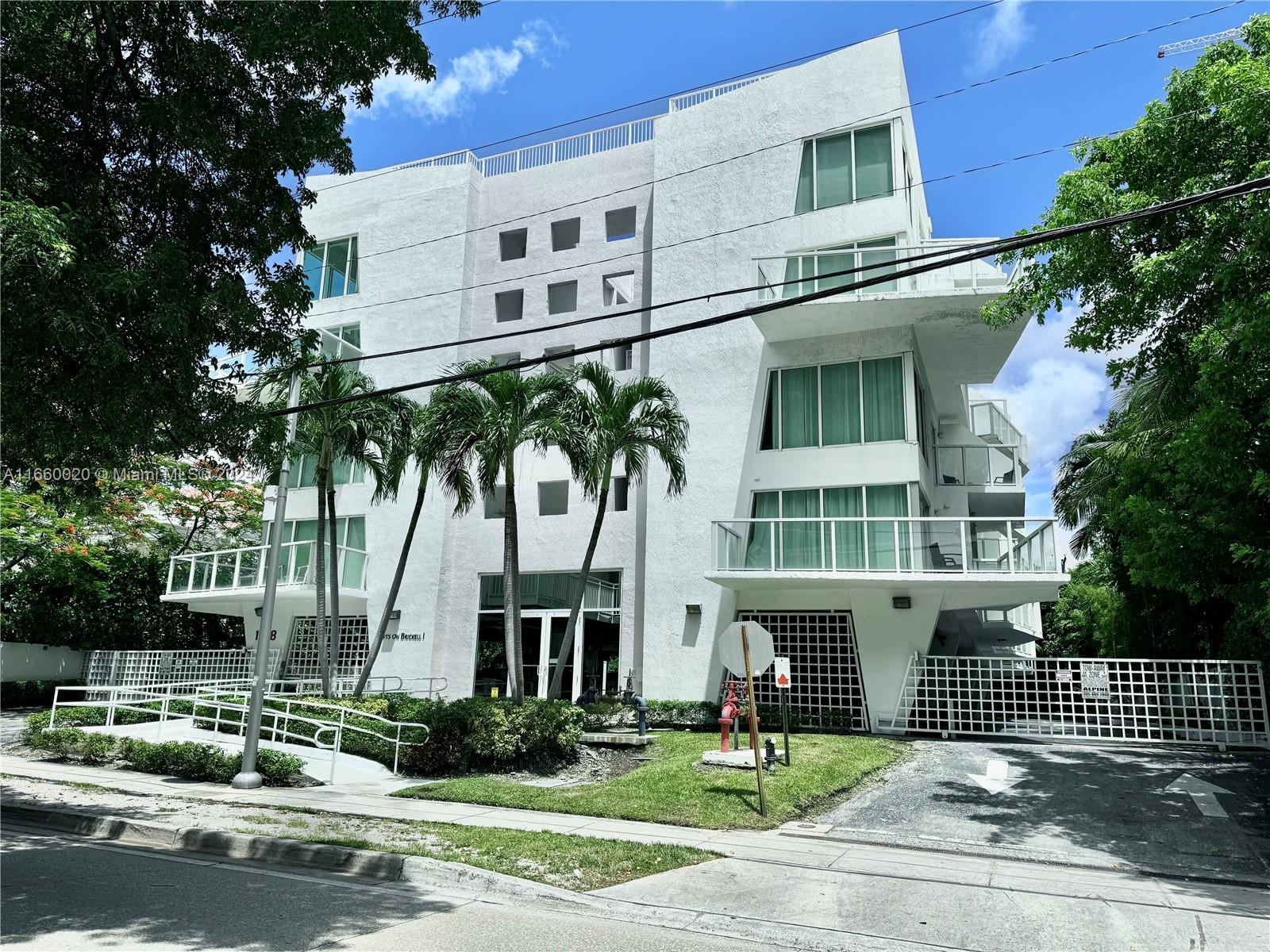 a front view of a building with a garden and plants