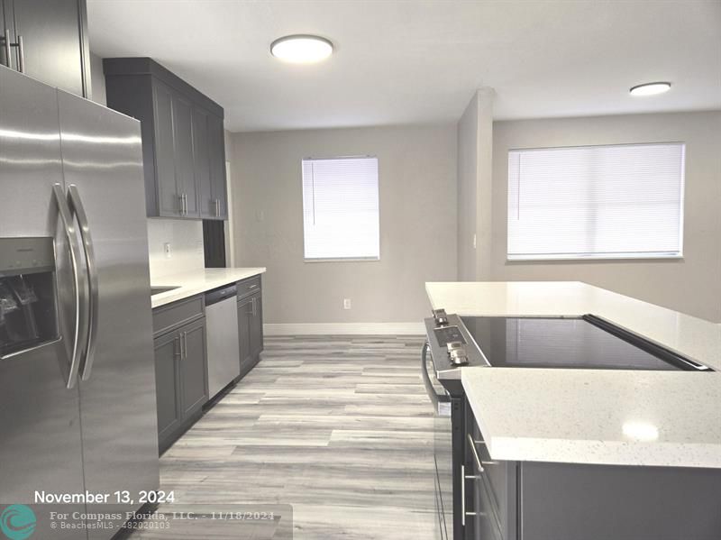 a kitchen with a refrigerator sink and cabinets