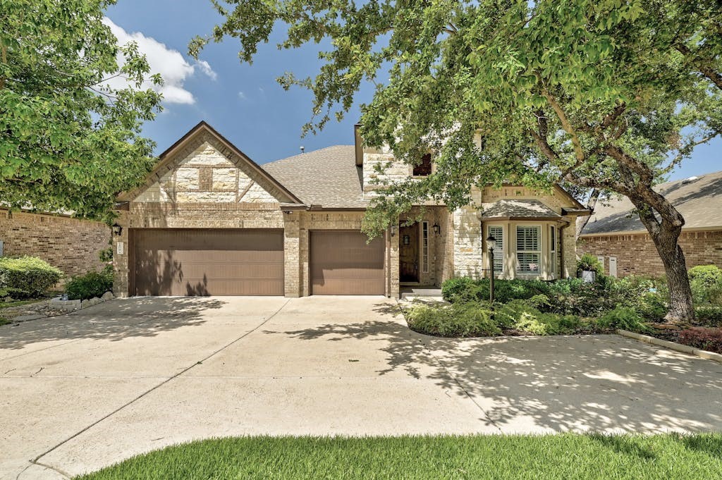 Grand entrance with 3-car garage, mature trees & meticulously landscaped front yard.