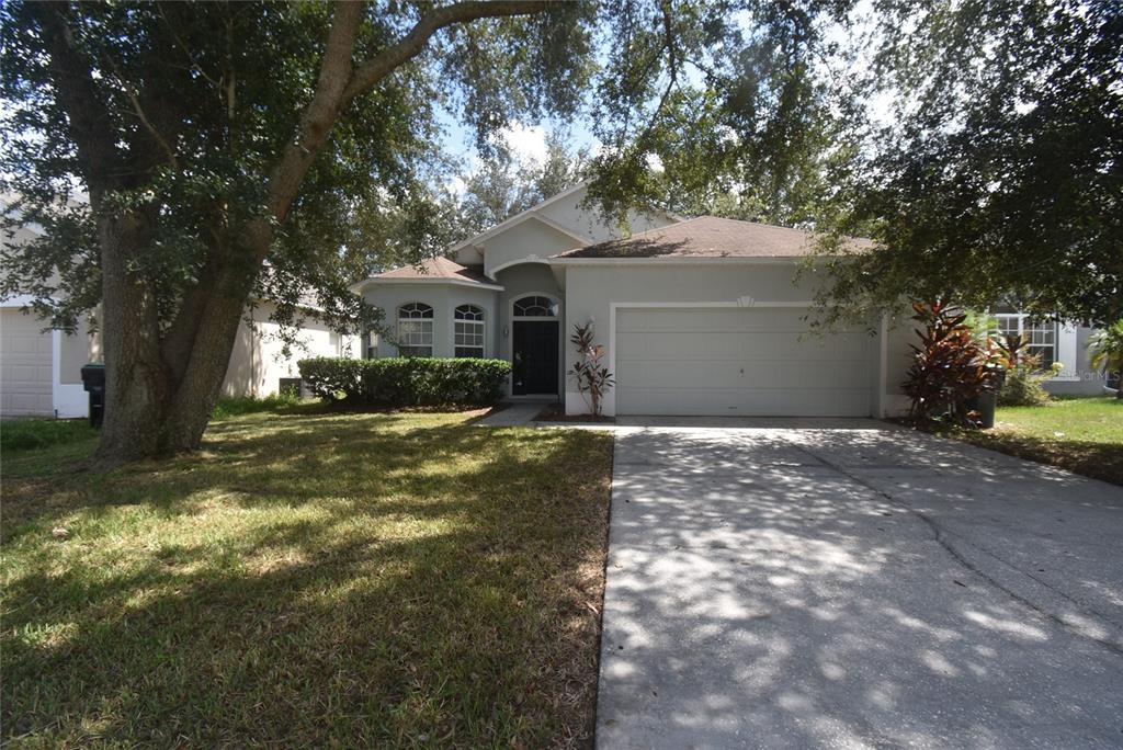 a front view of a house with a yard and trees