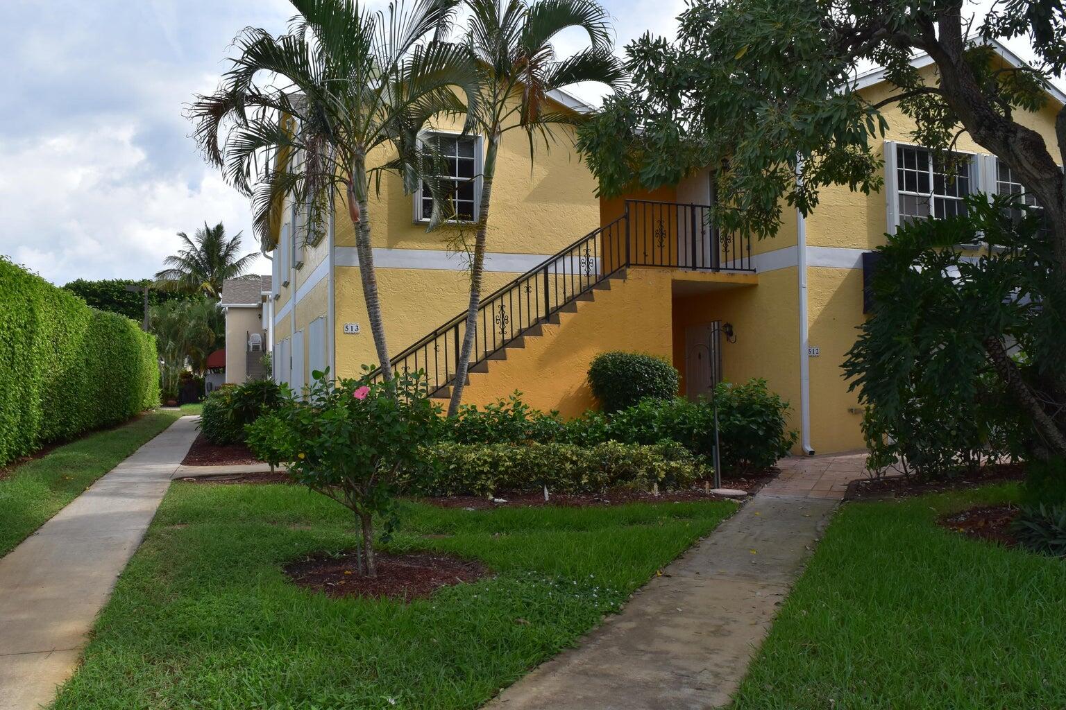 a front view of a house with a garden and trees