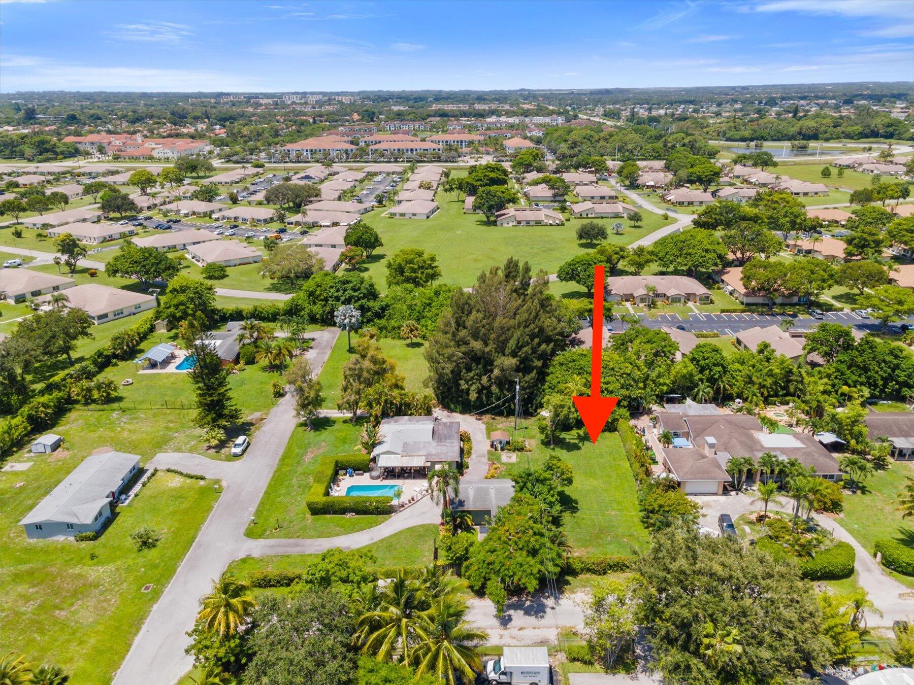 an aerial view of residential houses with outdoor space and trees