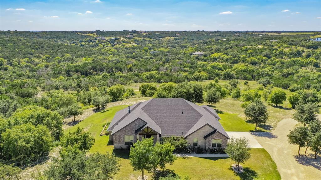 an aerial view of a house with a yard and lake view