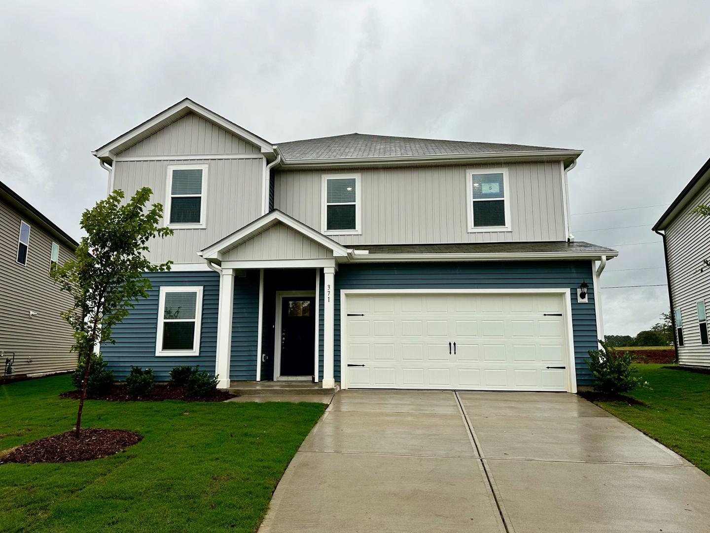 a front view of a house with a yard and garage