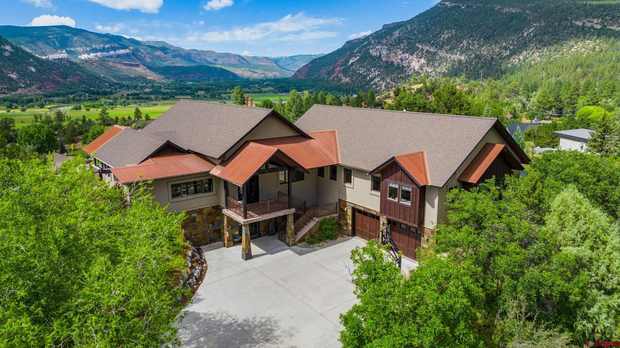 an aerial view of a house with swimming pool and mountains