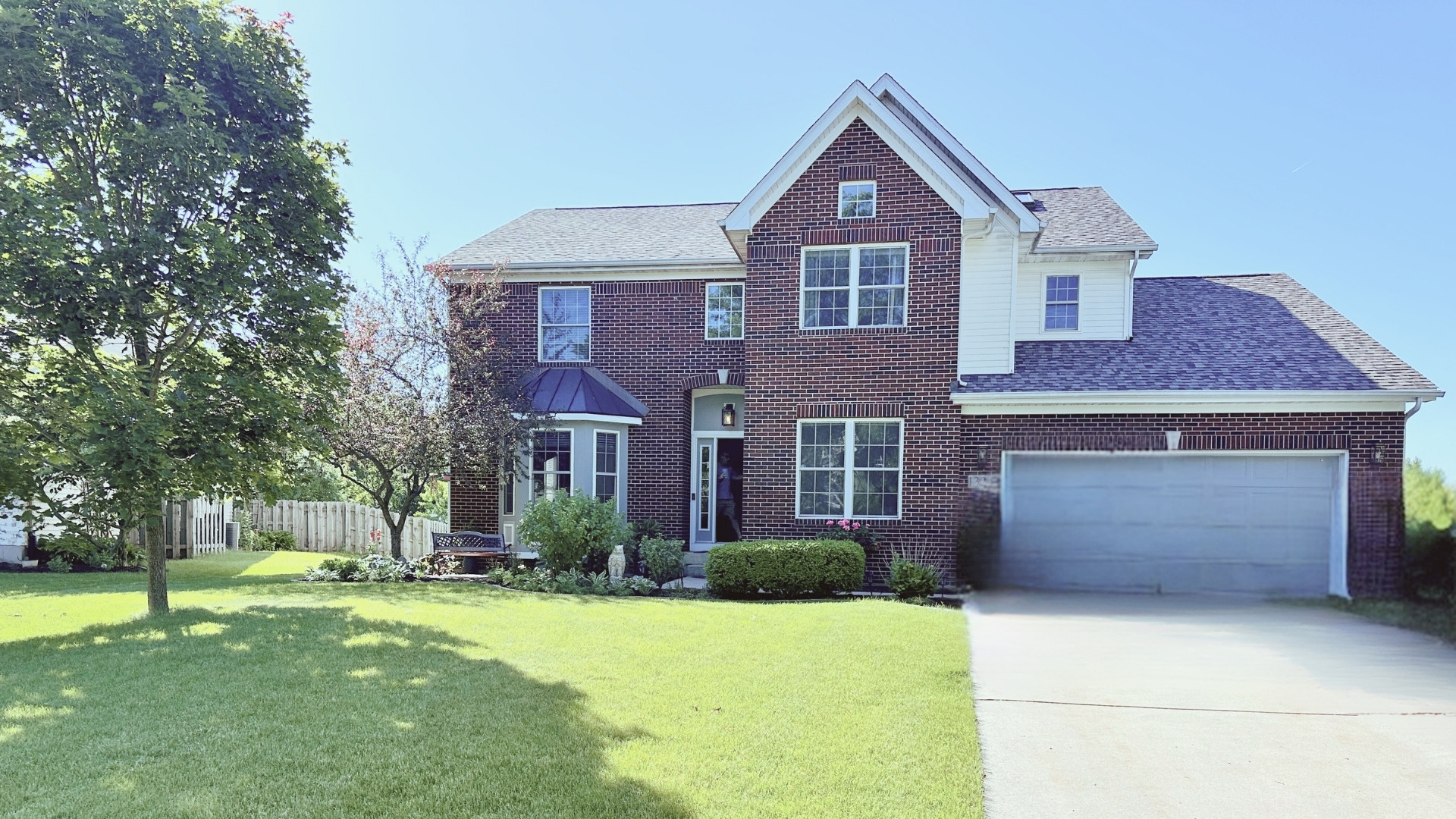 a front view of a house with a yard and trees