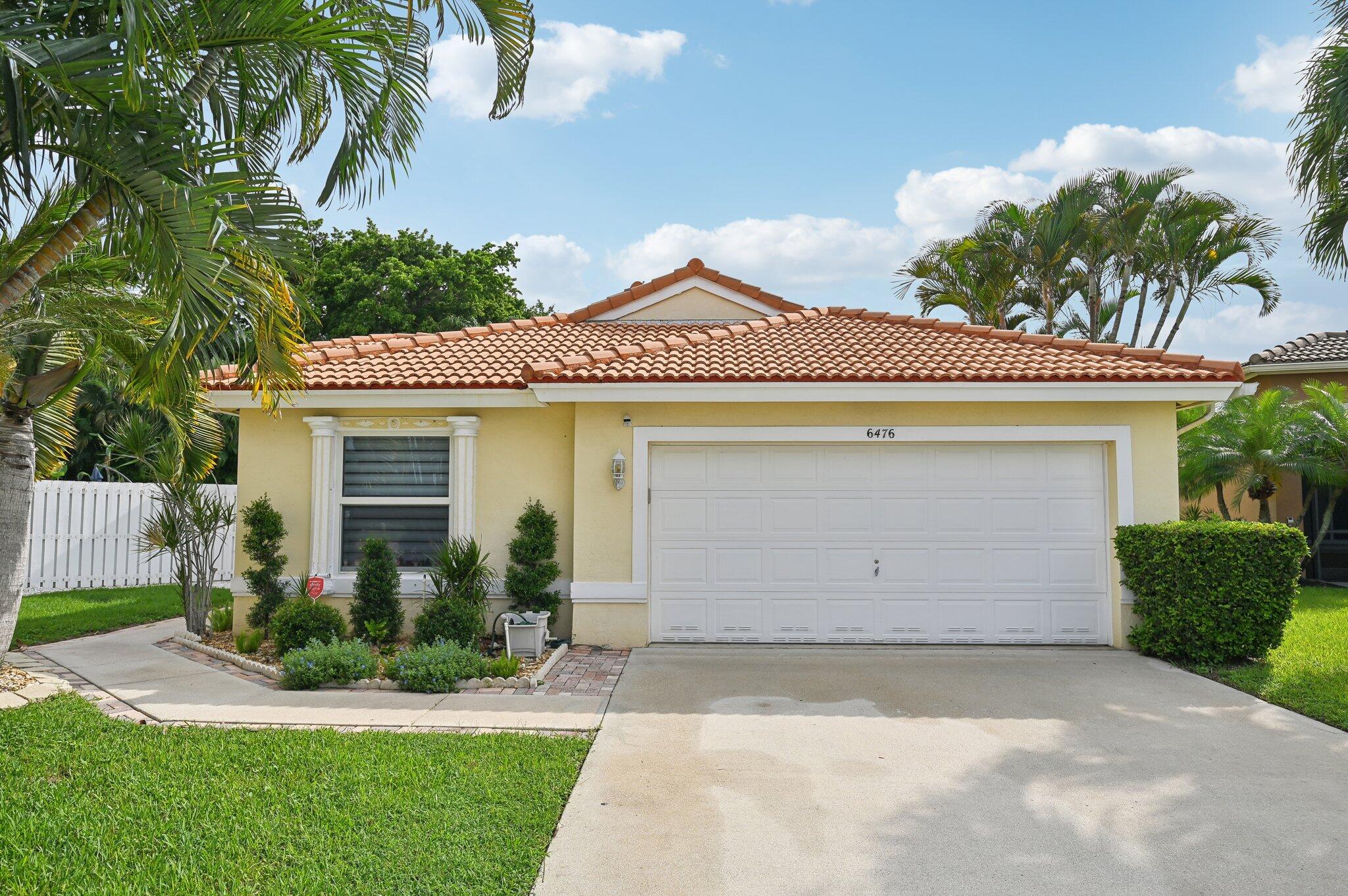 a front view of a house with a garden and a garage