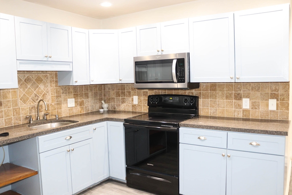 a kitchen with cabinets stainless steel appliances and sink