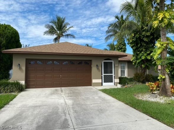 a front view of a house with a garden and palm trees