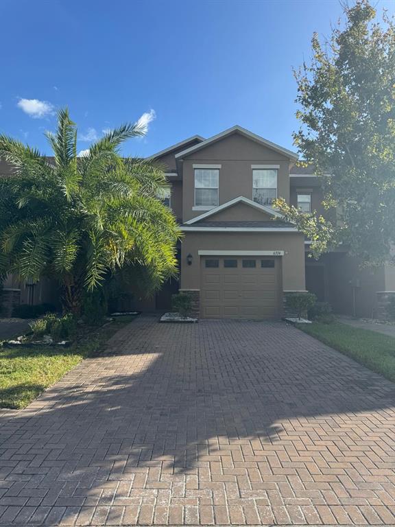 a front view of a house with a yard and a garage