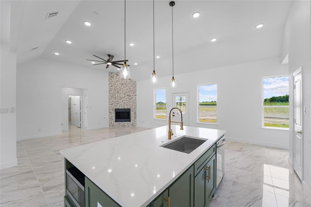 a kitchen with kitchen island a sink appliances and a counter top space