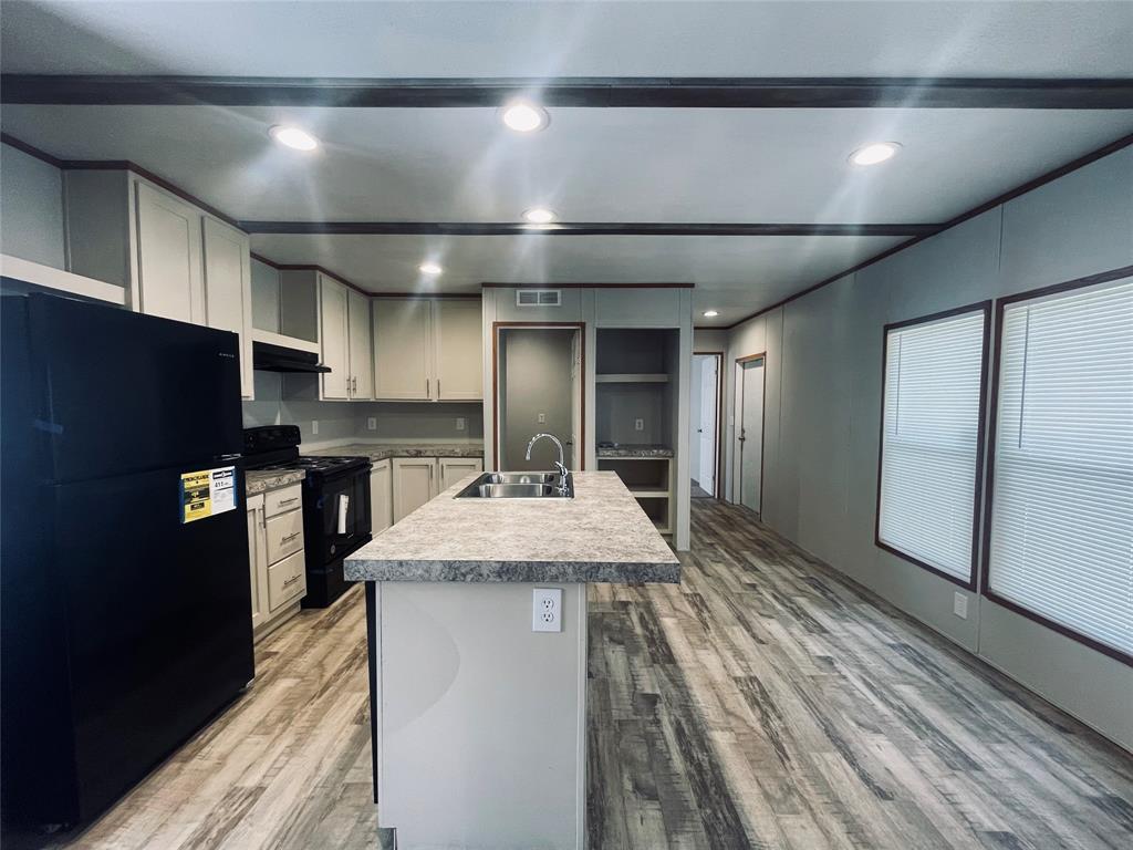 a kitchen with kitchen island a counter top space cabinets and stainless steel appliances