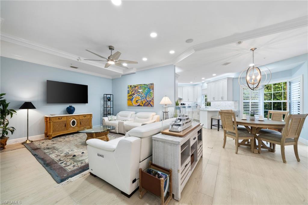 a living room with furniture kitchen view and a flat screen tv