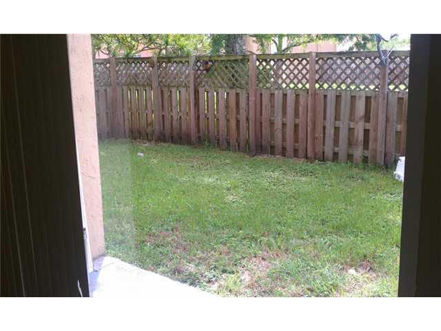 a view of backyard with wooden fence