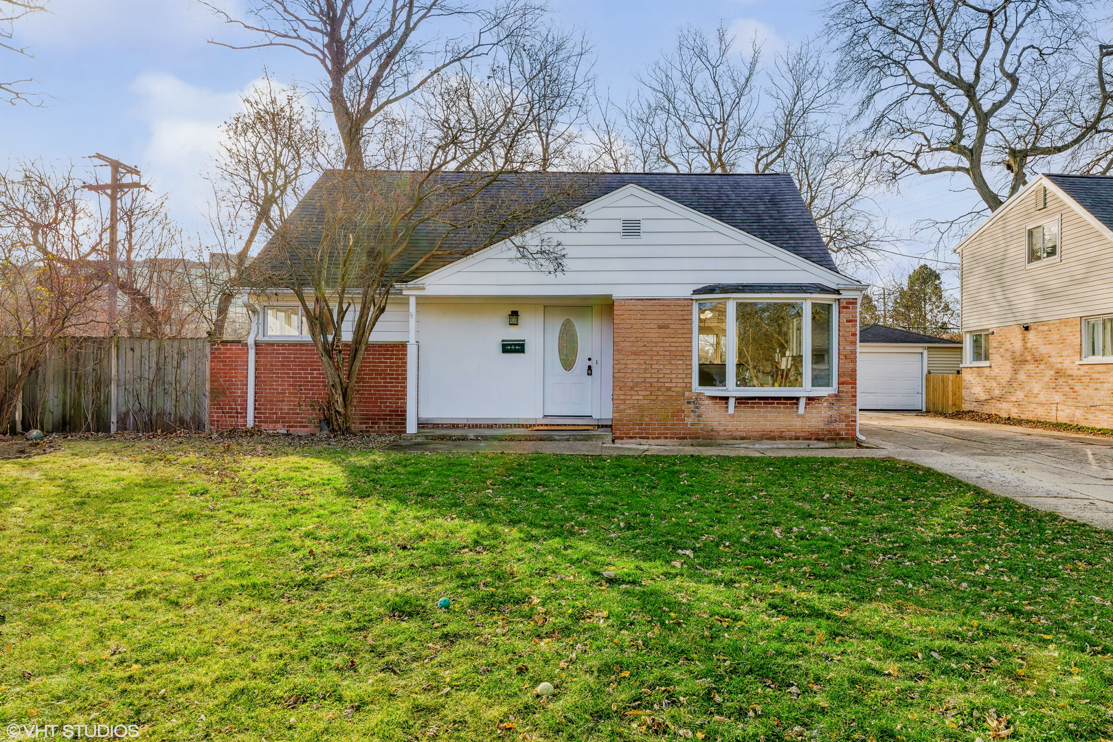 a front view of house with yard and trees