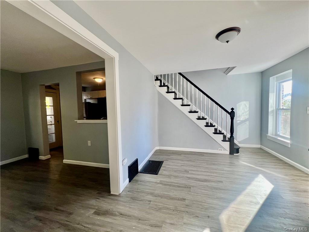 a view of a hallway with wooden floor and staircase