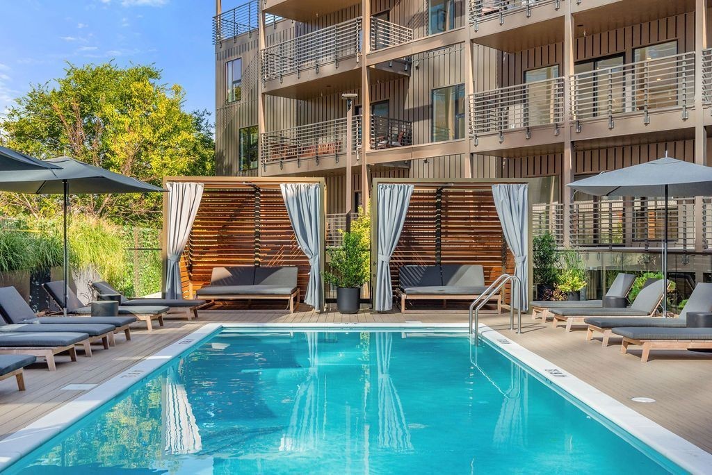 a view of pool with outdoor seating and city view