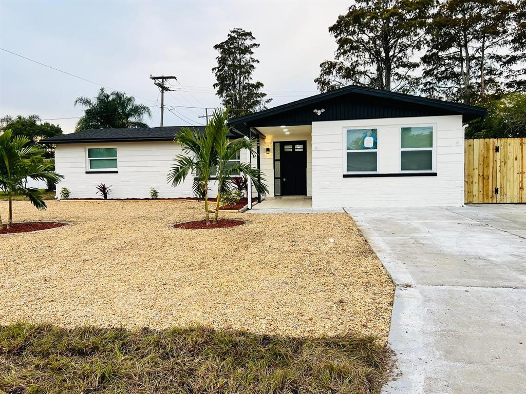 a view of a house with backyard and trees