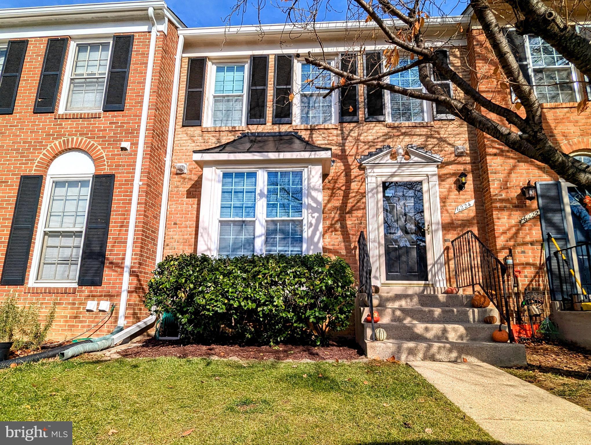 front view of a brick house with a yard