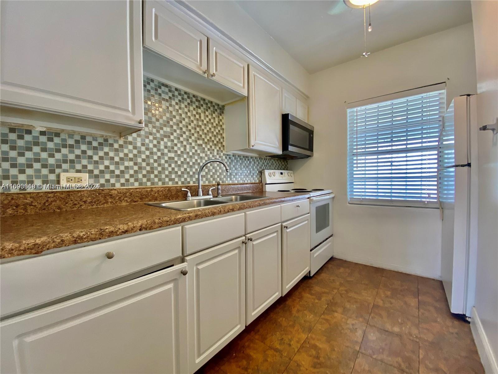 a kitchen with sink cabinets and microwave