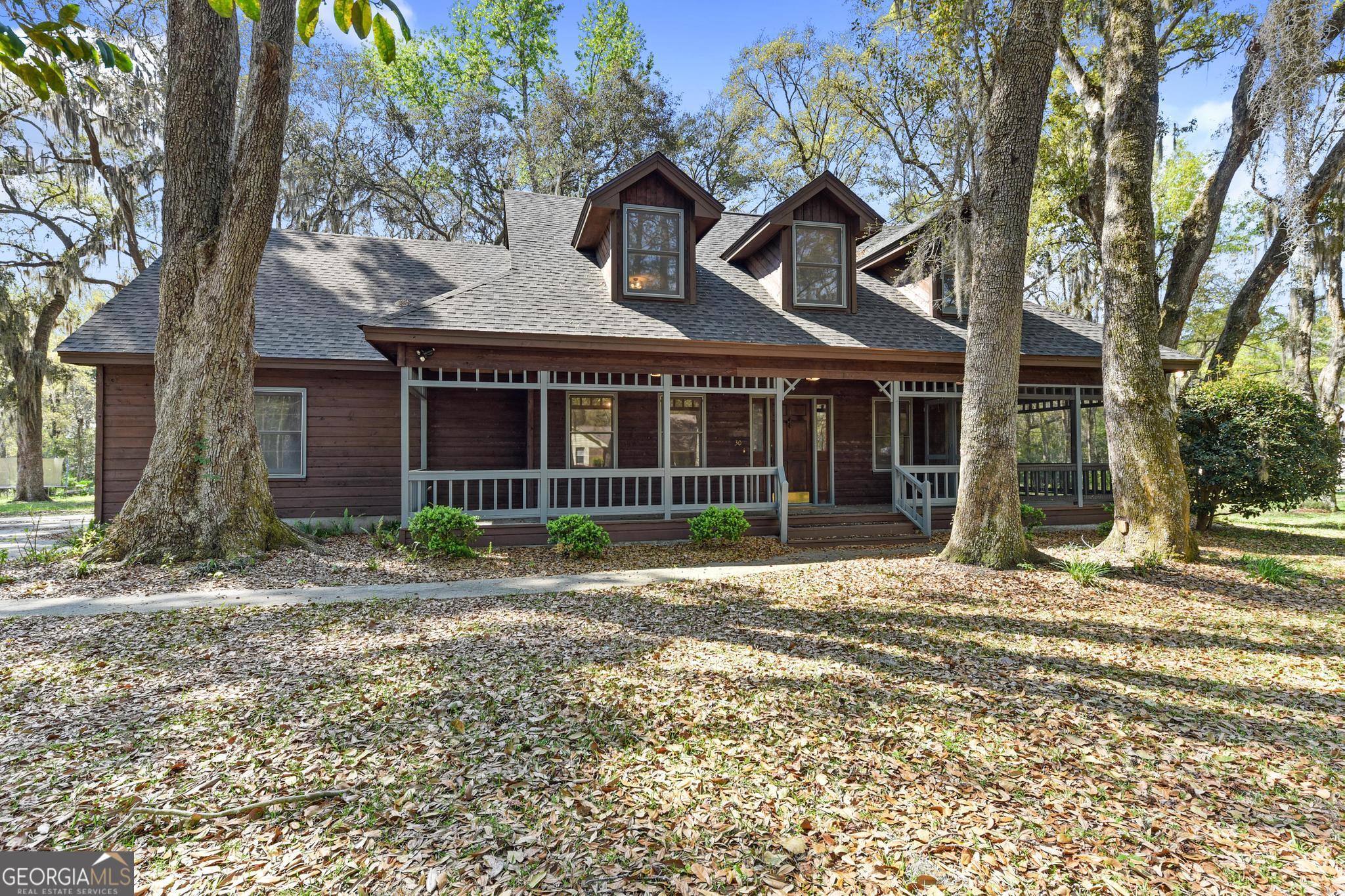 a view of a house with a yard and large tree