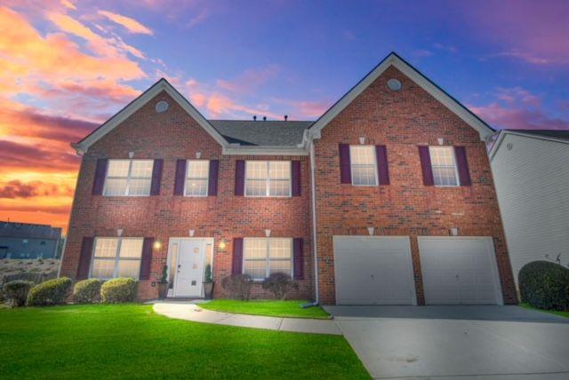 a front view of a house with a yard and garage