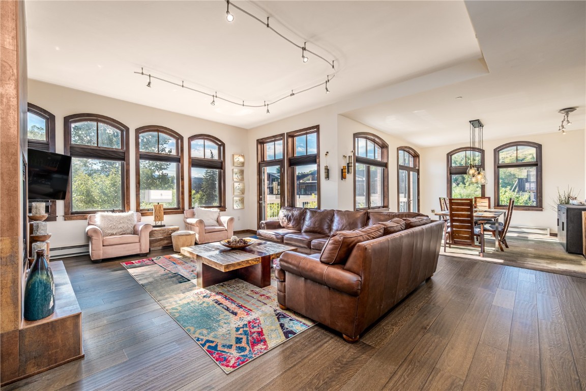 a living room with furniture floor to ceiling window and wooden floor