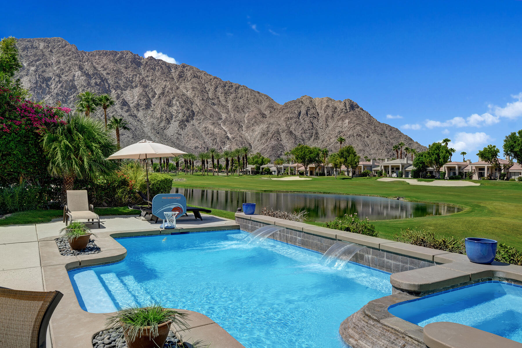 a view of a swimming pool and lounge chairs in back yard