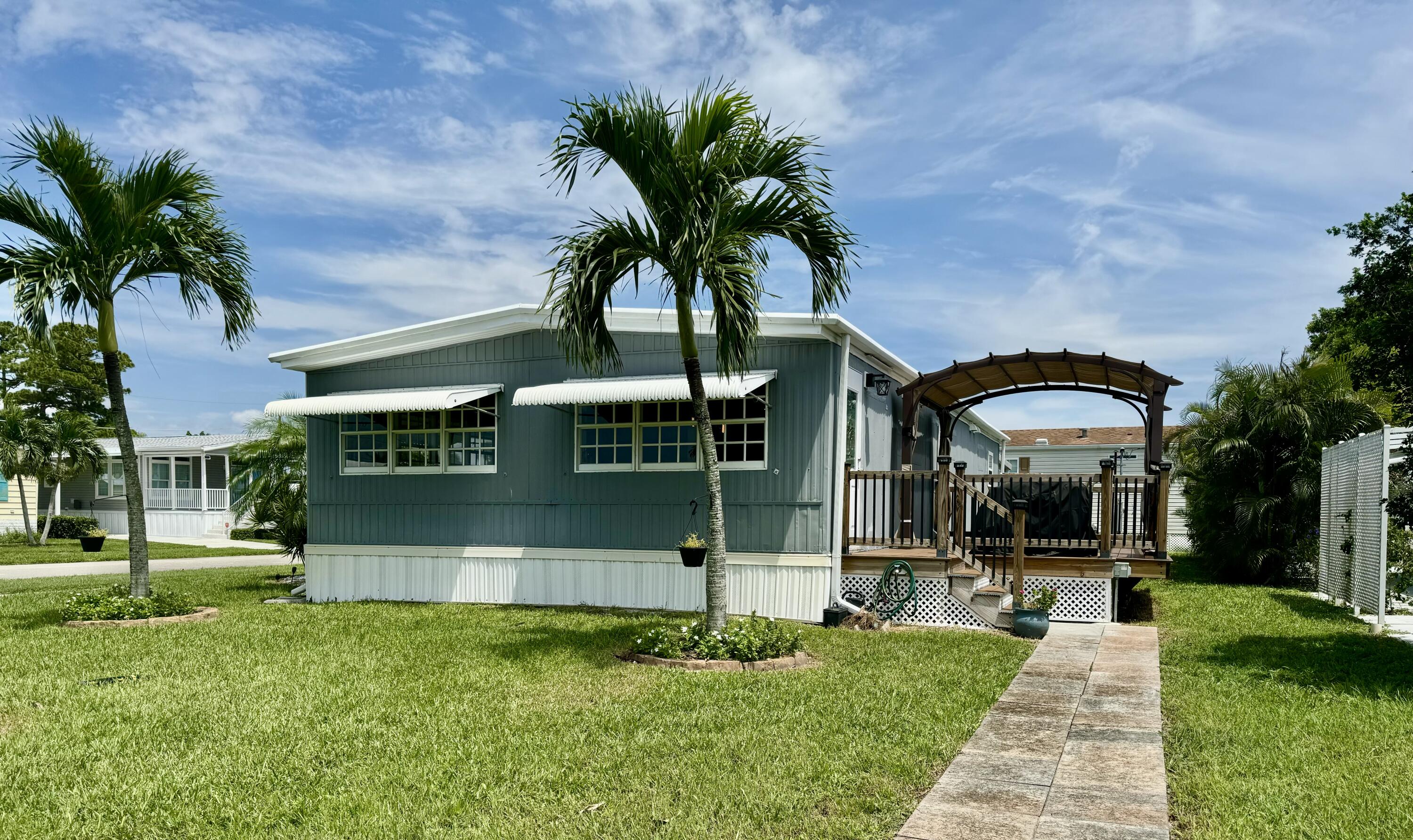 a view of a house with a yard and potted plants