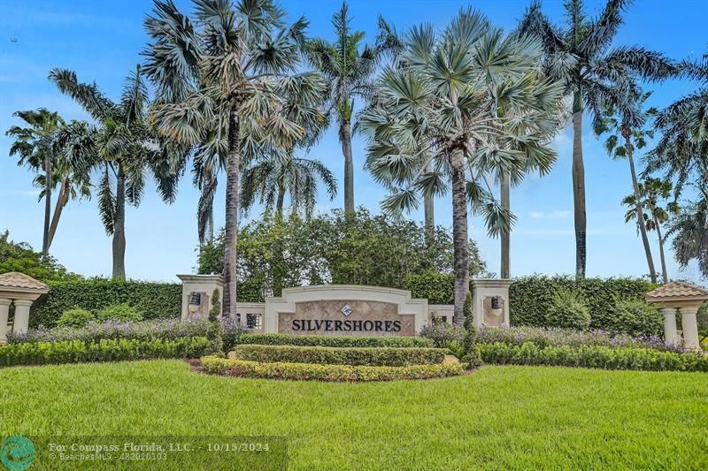 a view of a white house with a yard and palm trees