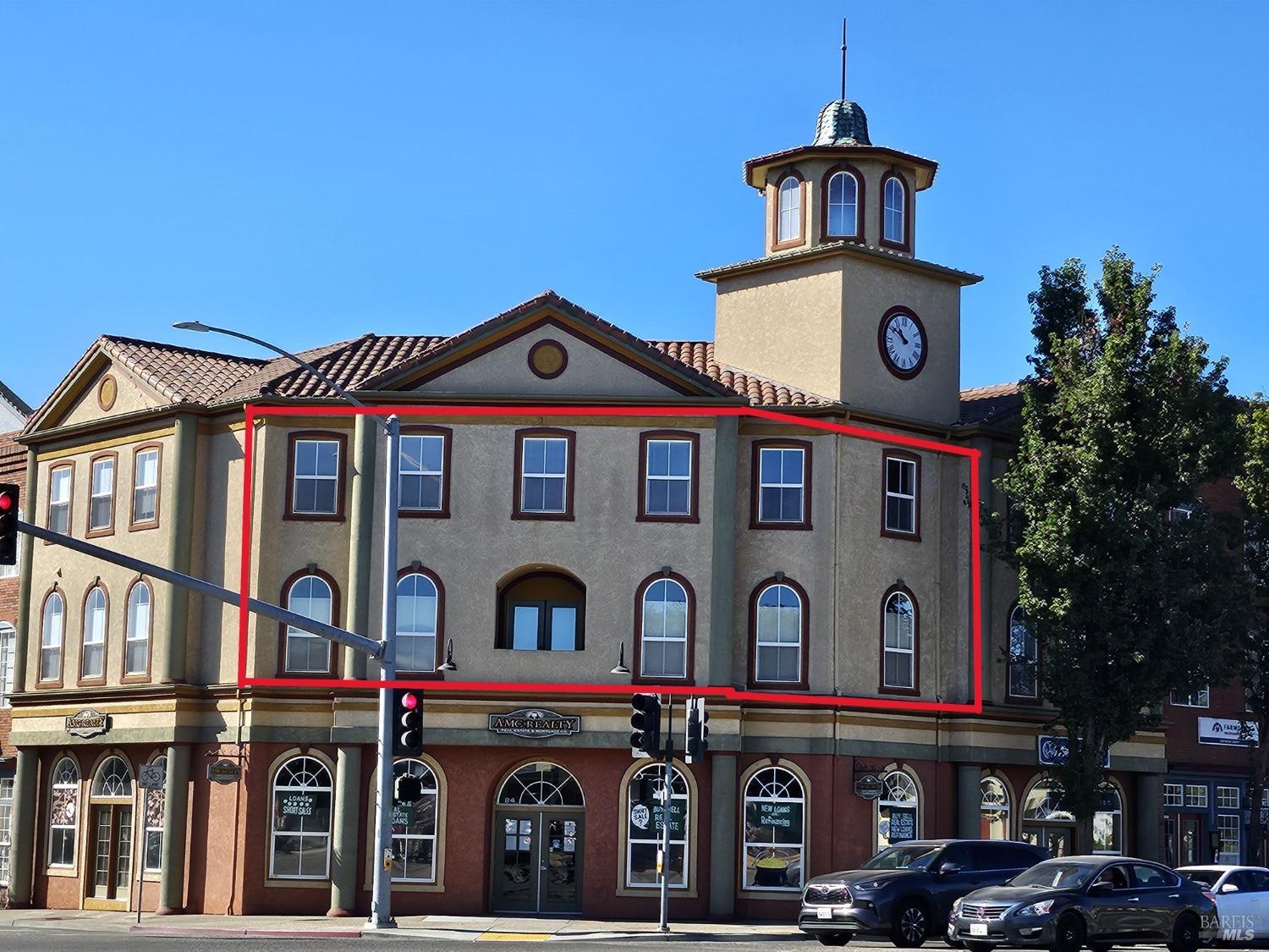 a front view of a building with parking lot of front of it