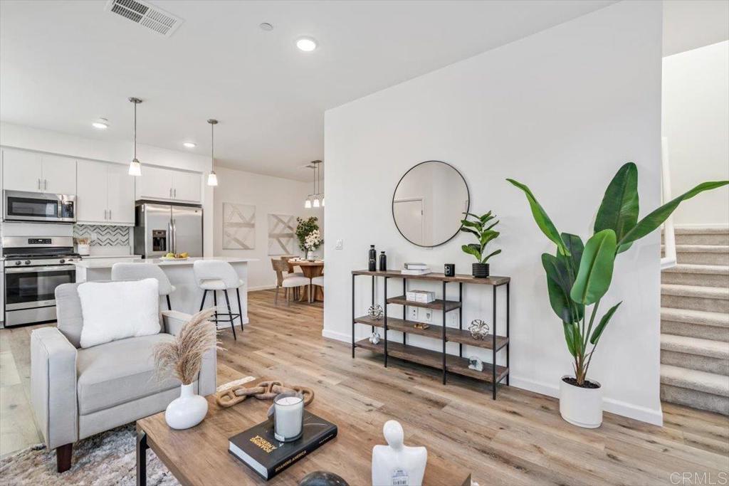 a living room with furniture a wooden floor and a potted plant