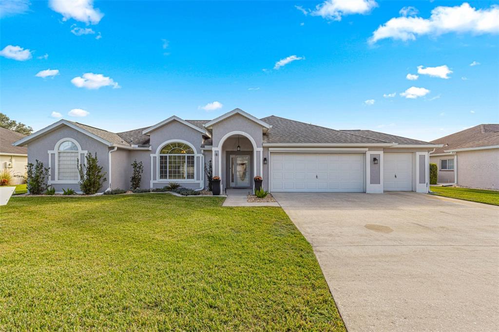 a front view of a house with yard and parking space