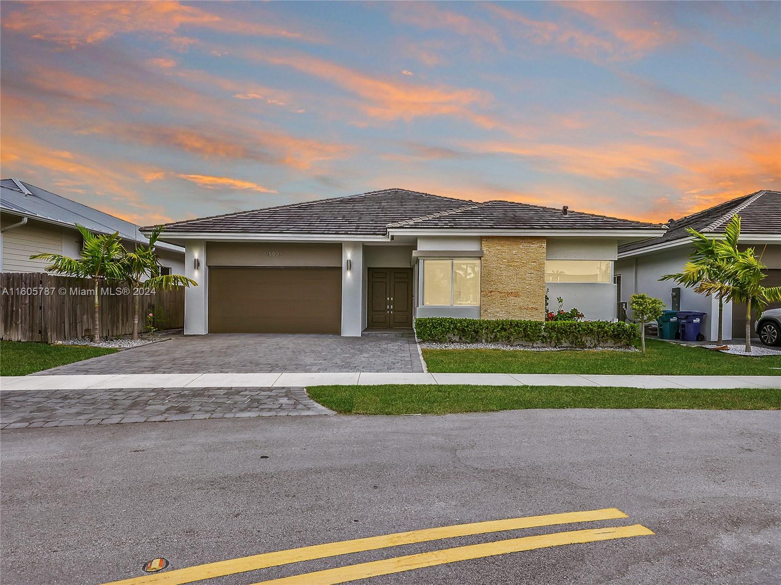 a front view of a house with a yard and garage