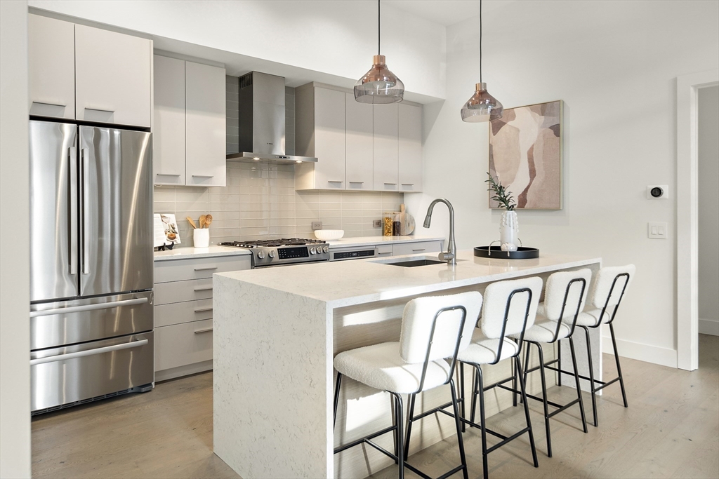 a kitchen with white cabinets and stainless steel appliances