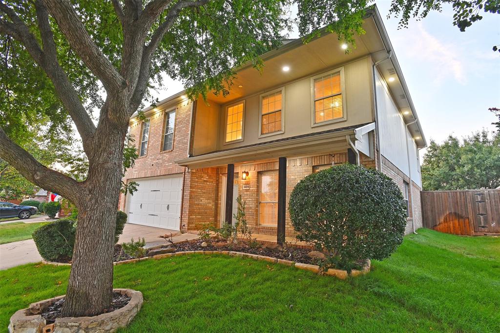 View of front of house featuring a front lawn and a garage