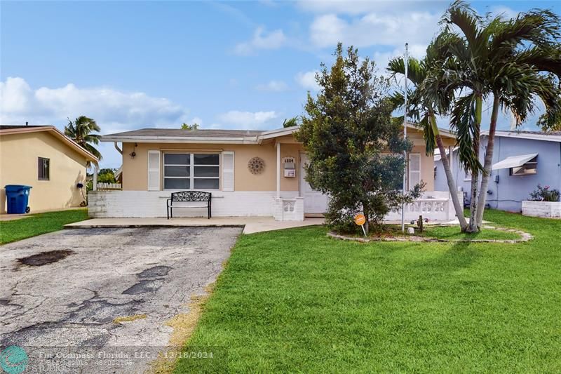 a view of a house with backyard and a tree