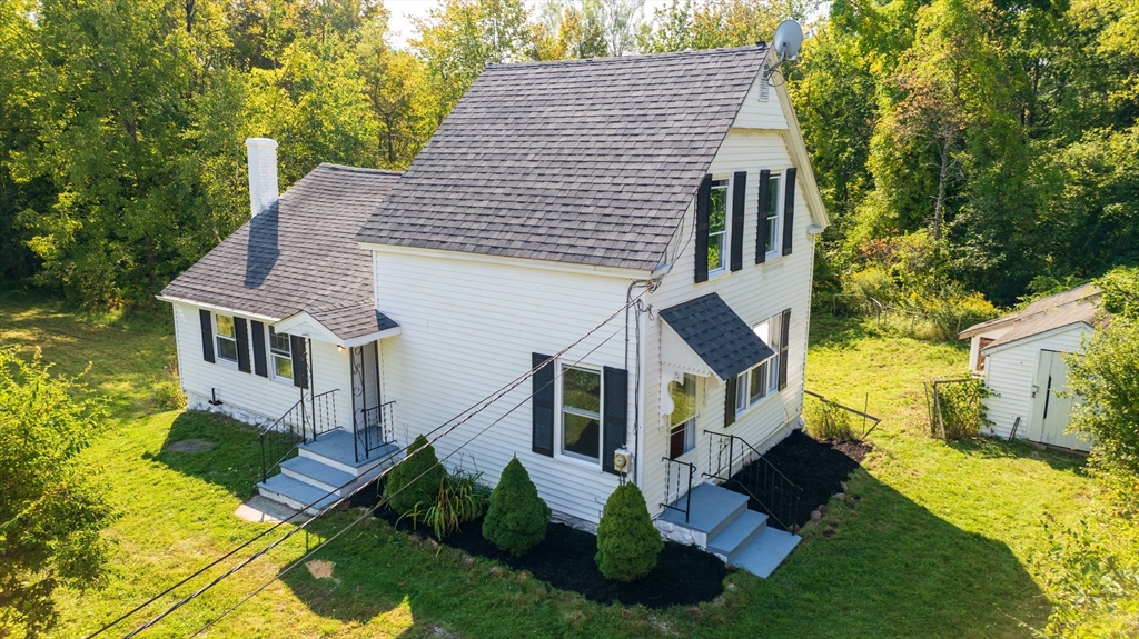 a view of house with yard and car parked