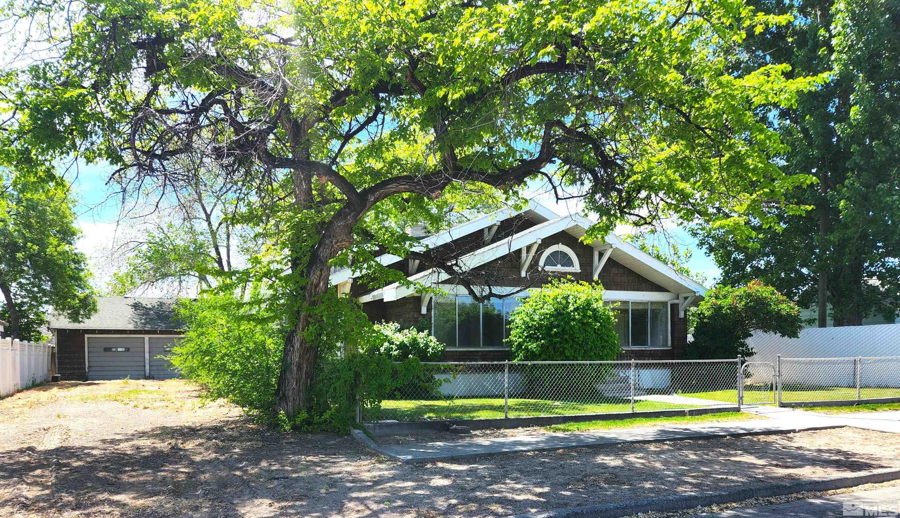 a view of a house with pool plants and large trees