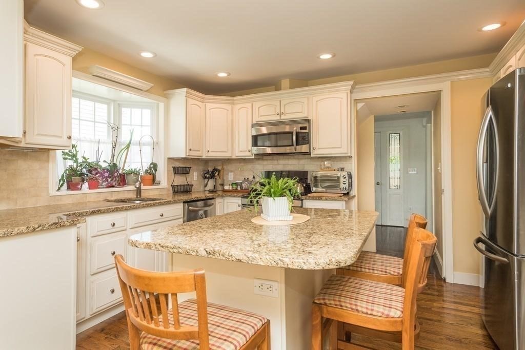 a kitchen with kitchen island granite countertop a sink and cabinets