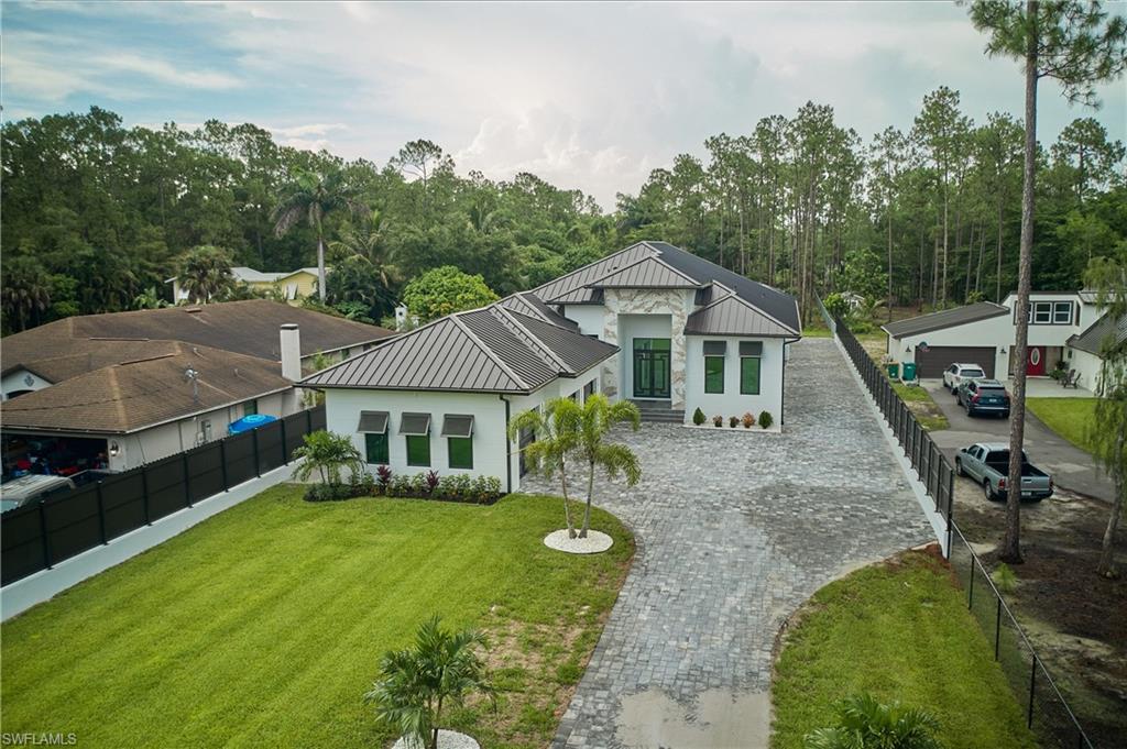 View of front of house with an outdoor structure, a garage, and a front yard