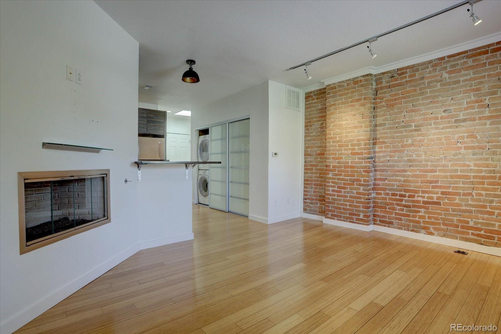 a view of empty room with wooden floor and fireplace