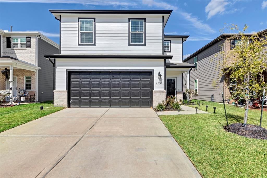 a front view of a house with a yard and garage