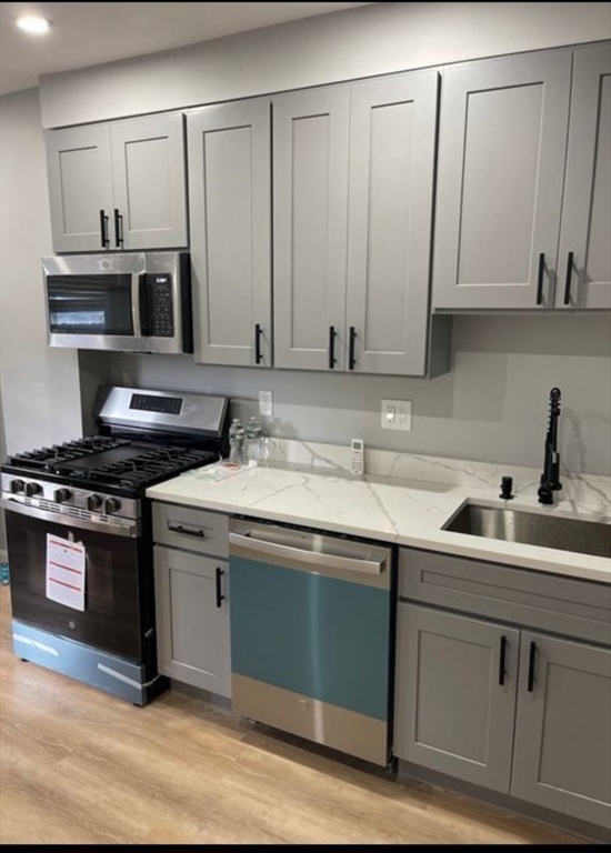 a kitchen with stainless steel appliances granite countertop a sink and a stove